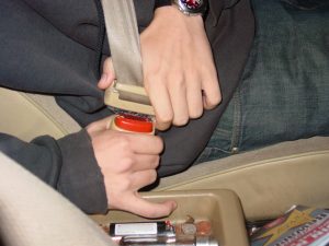 close up of teen buckling his seatbelt