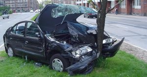 damaged car after accident hitting tree in median