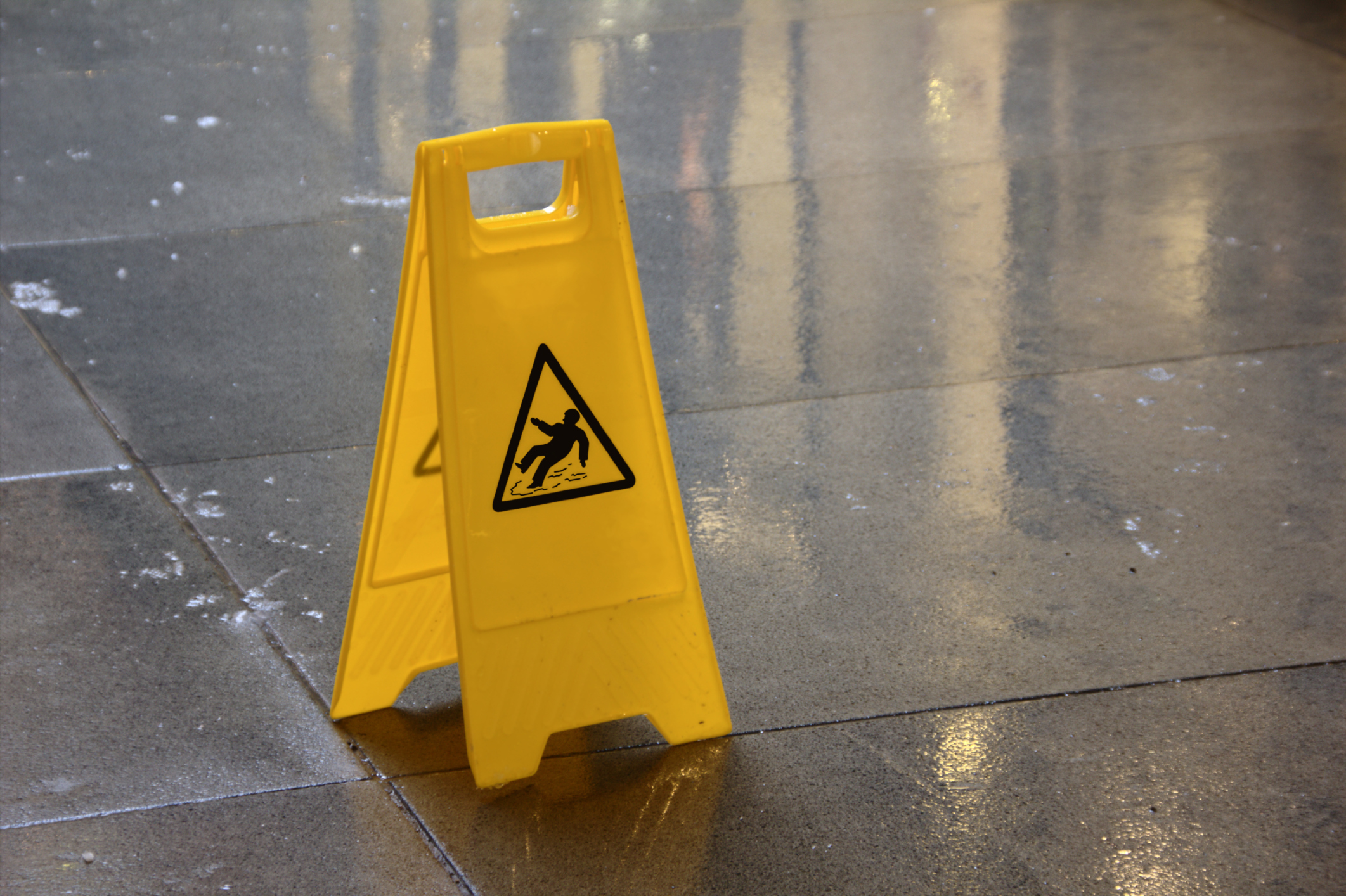 slippery floor sign on wet, icy sidewalk