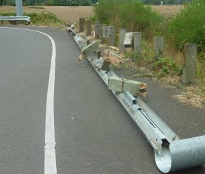 damaged guardrail on side of road after car accident