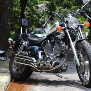 teal white and black yamaha motorcycle parked on side of road