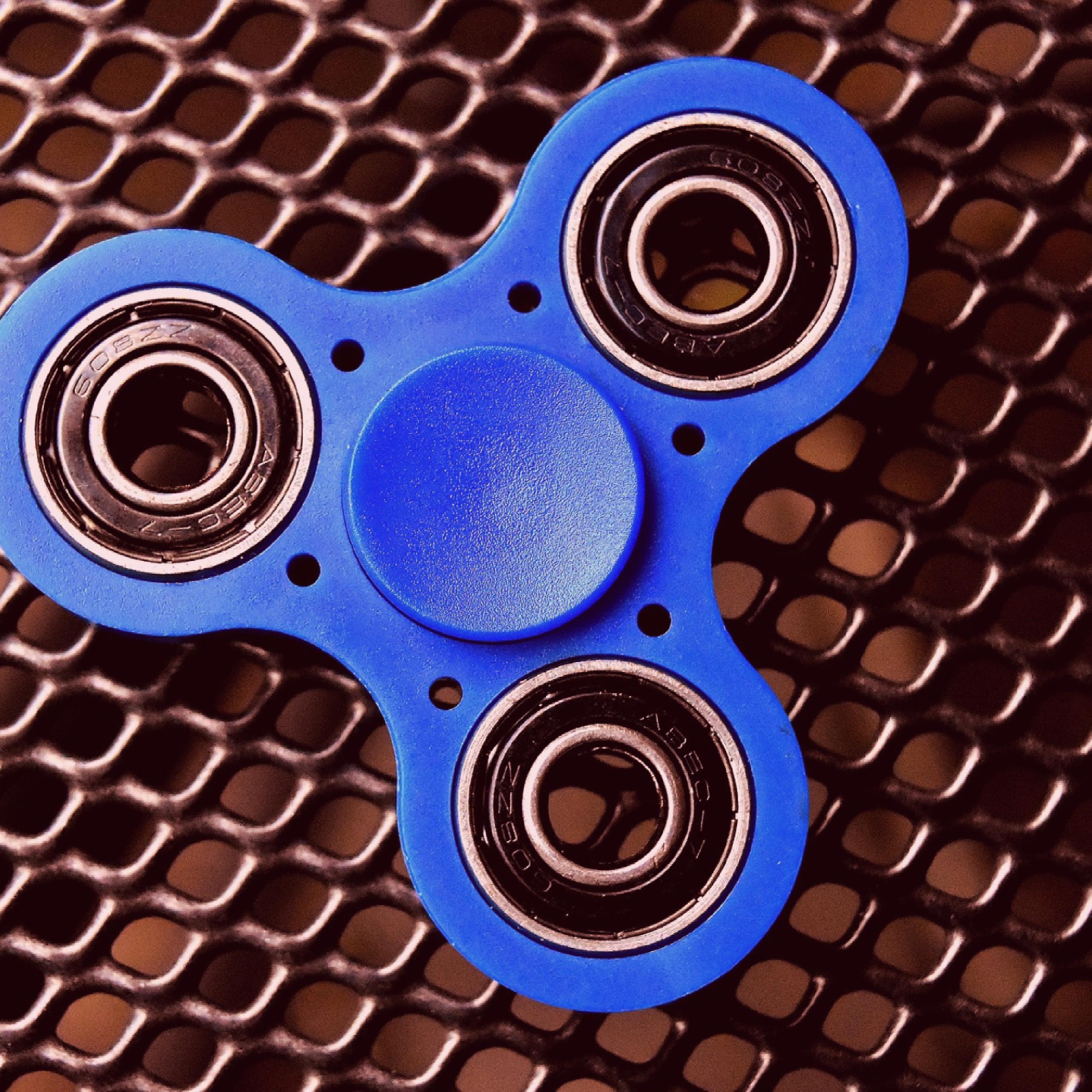 blue fidget spinner on metal table