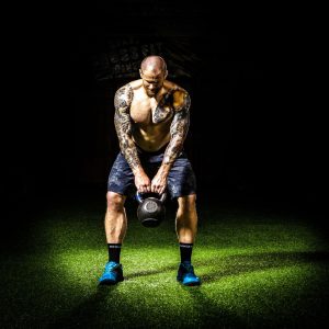 tattooed man lifting weights