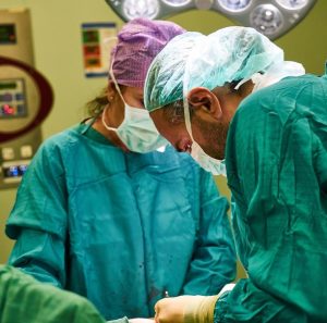 close up of male and female doctors performing surgery