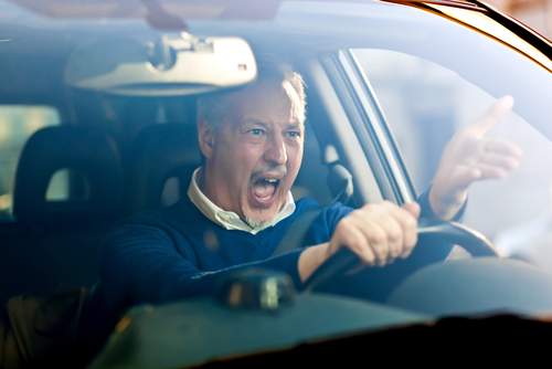 angry male driver with road rage yelling and pointing