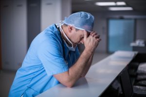 tired doctor in blue scrubs