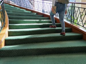 person climbing stairs with carpet