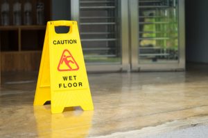 caution wet floor sign in commercial building before exit