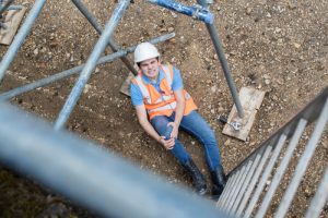 construction worker with leg injury after falling from scaffolding at job site