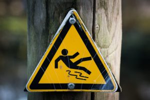 slippery warning sign on wooden post