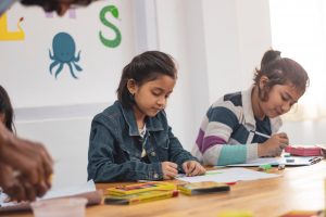 children coloring in class at school