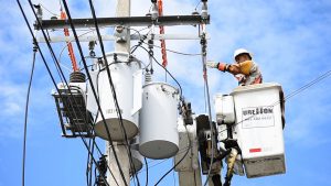 utilities worker in lift working on power lines