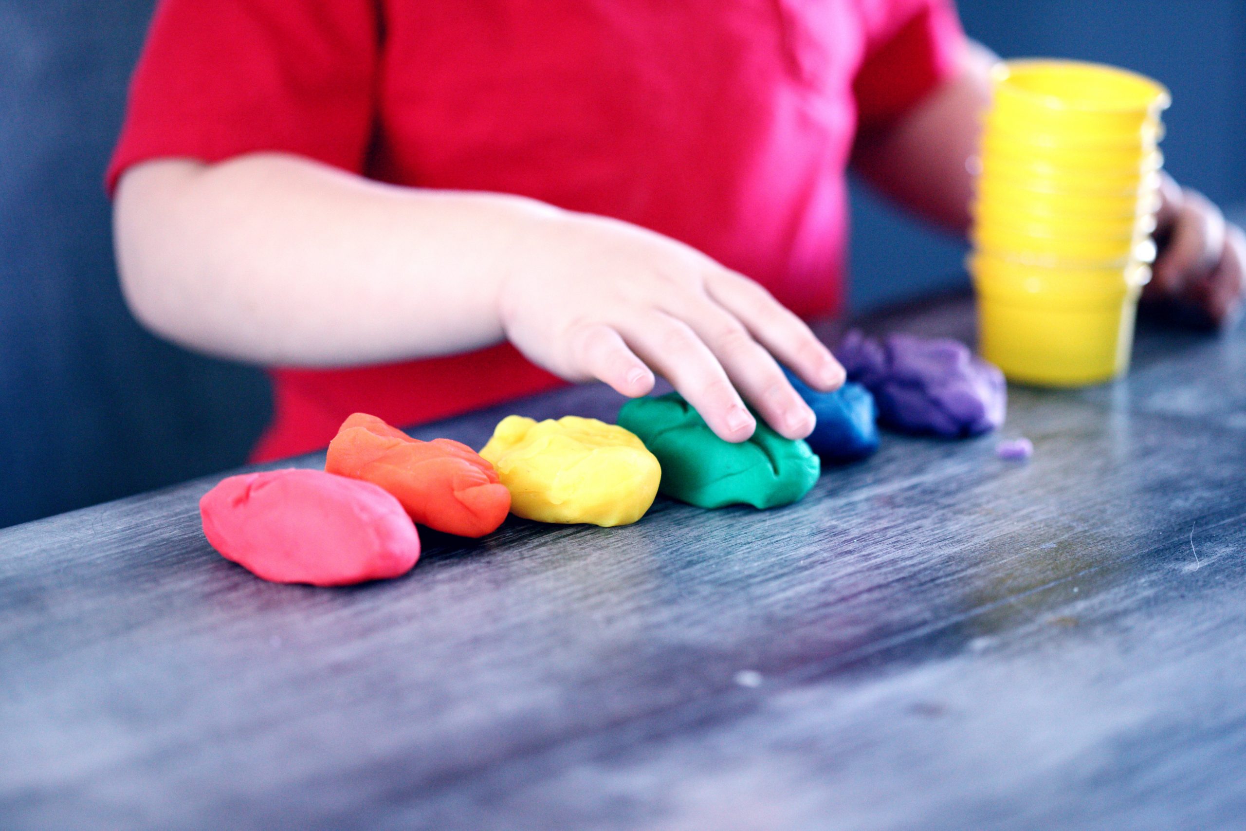 child playing with different colors of clay
