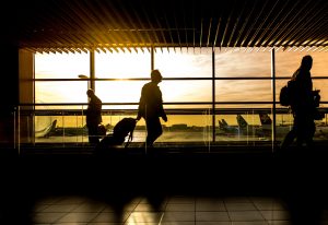 silhouettes of passengers walking through airport