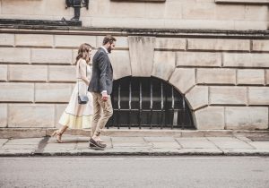 man and woman in formal clothes walking in city