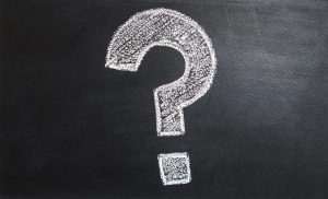 chalk question mark drawn on black chalkboard