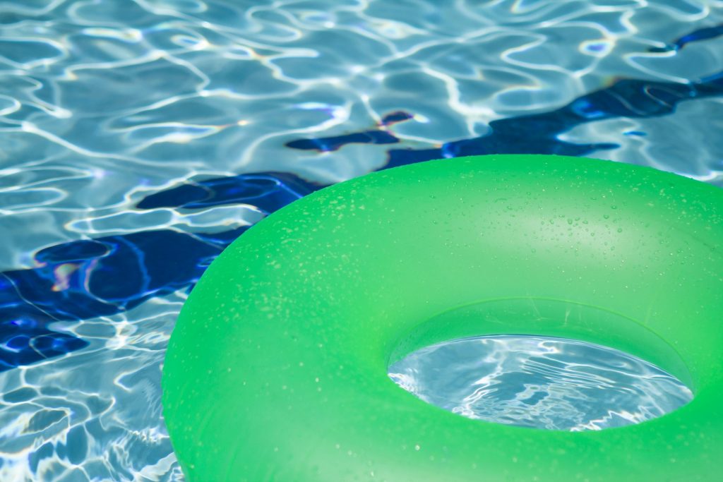 close up of green tube floating in swimming pool