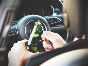 drunk driver opening beer in drivers seat