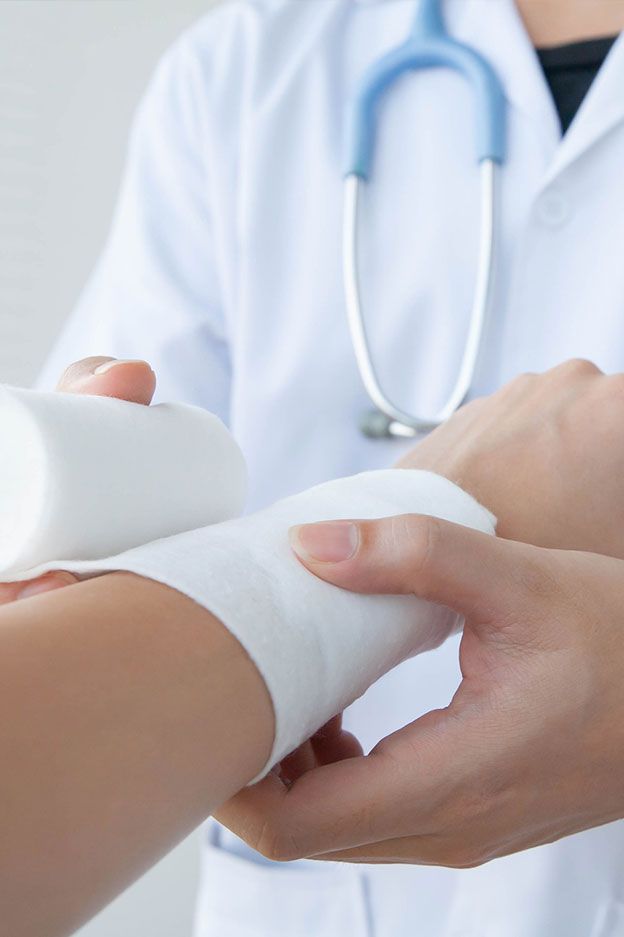 close up of doctor dressing wounds of patient with severe burn injury on arms
