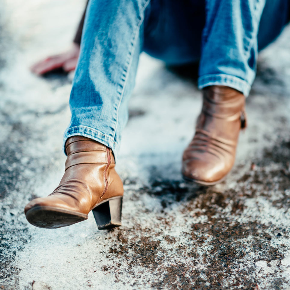 woman on ground after slipping and falling from icy sidewalk