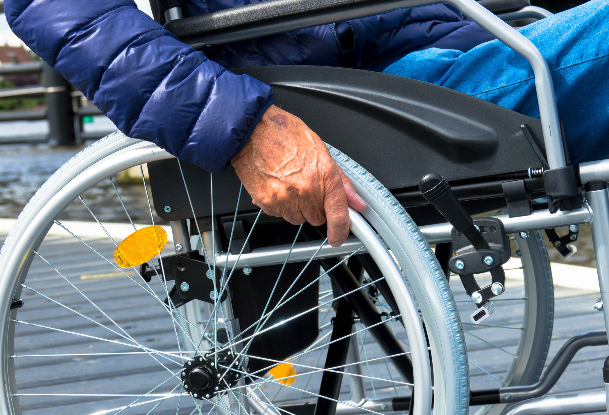 Close up of hands disabled senior sitting on wheelchair at outdoor
