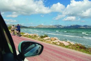 car side view with mirror driving along coast in summer