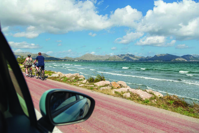 car side view with mirror driving along coast in summer