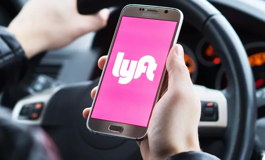close up of lyft driver viewing app on phone while driving