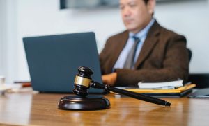 judge sitting at desk with laptop and gavel