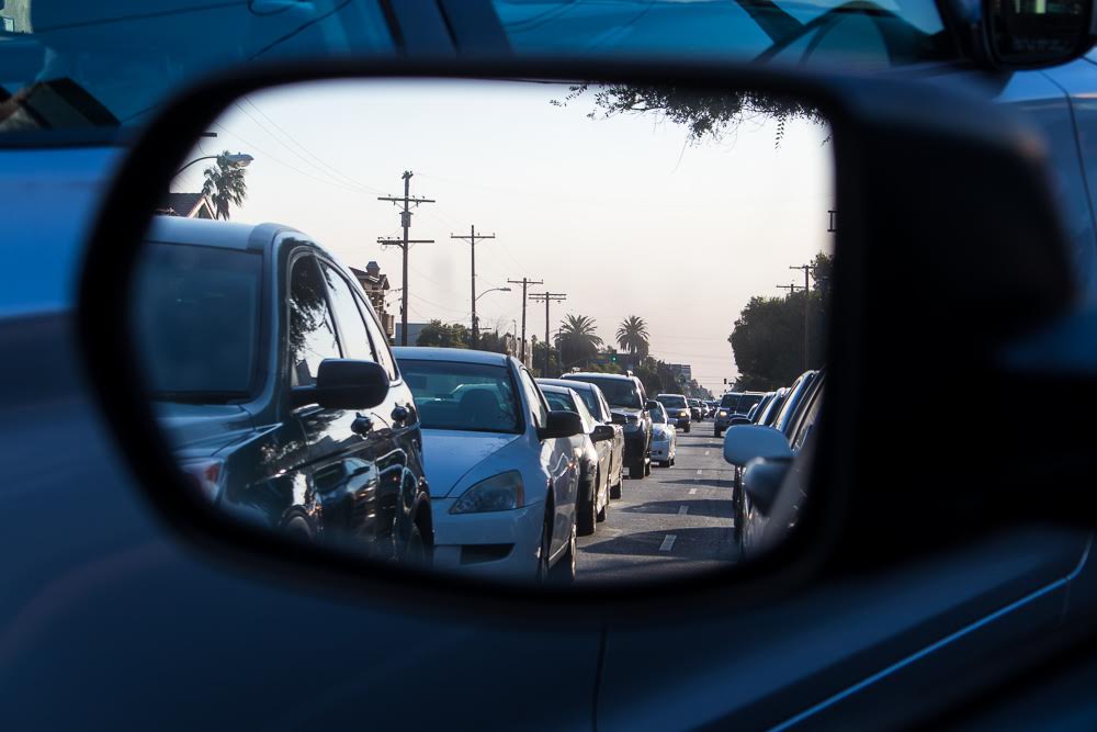 traffic on road seen through car mirror