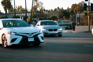 two cars merging on road near apartment building