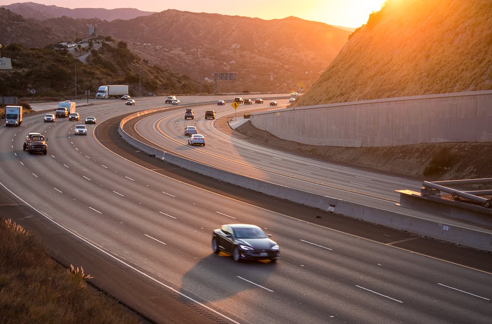 cars driving on highway at dusk