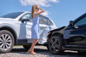 female driver standing on street after crash