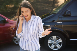stressed woman talking on phone after crash