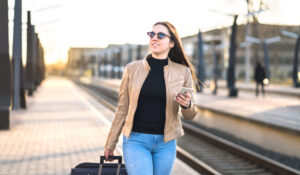 woman using cell phone as train pulls in