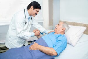 doctor consulting with older burn victim in hospital bed