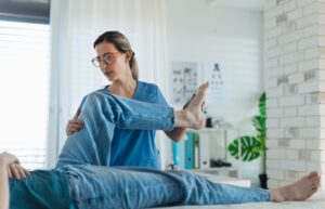 physical therapist helping patient with leg pain
